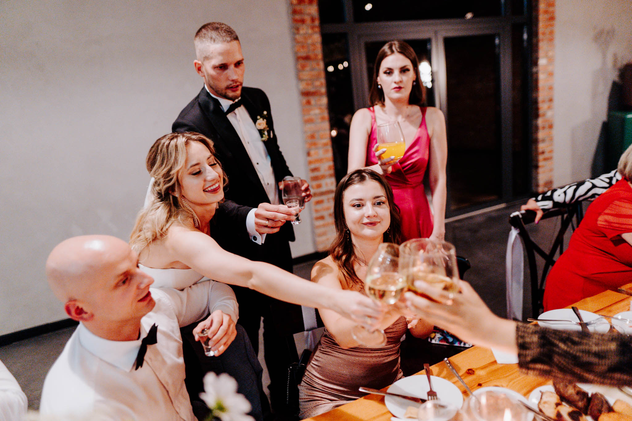 Para młoda przy stole z gośćmi podczas wesela