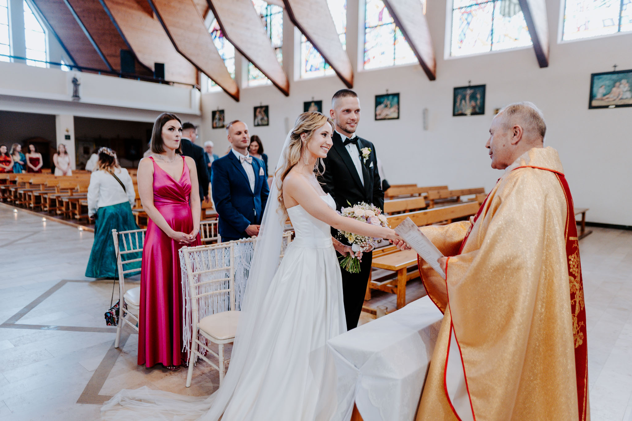 Ksiądz przekazujący dokumenty ślubne parze młodej po zakończeniu mszy ślubnej